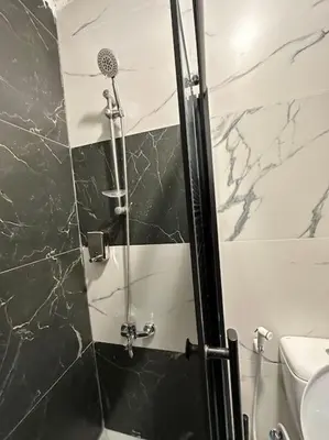 a shower with a glass door in a bathroom at Stylish Luxe Apartment F-R 0003 in Amman