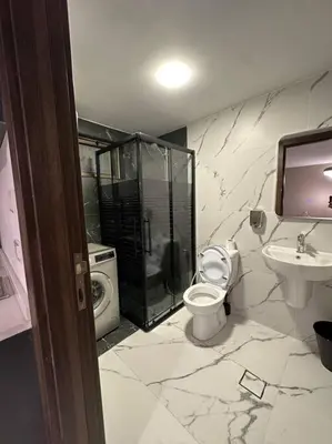 a bathroom with a shower and a toilet and a sink at Stylish Luxe Apartment F-R 0006 in Amman