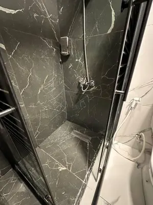 a shower with a black and white marble shower stall at Stylish Luxe Apartment F-R 0006 in Amman