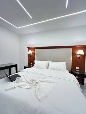 a large white bed with a blanket on it at Jerash Hotel in Jerash