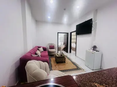 a living room with a purple couch and a tv at Jerash Hotel in Jerash