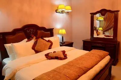 a bedroom with a large bed with a large mirror at Jad Hotel & Suite in Umm Uthainah