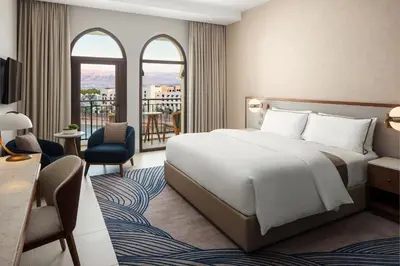a hotel room with a bed and a balcony at The Westin Saraya Aqaba Resort & Spa in Aqaba