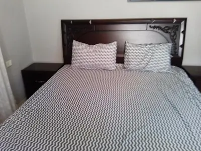 a bed with two pillows on top of it at Ayola Apartment in Madaba