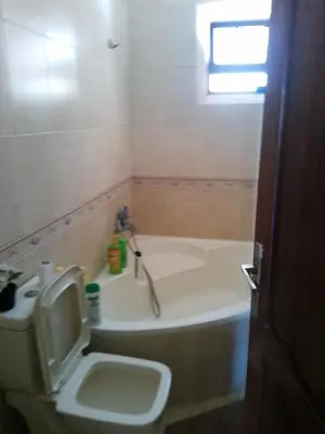 a bathroom with a tub and a toilet and a sink at Ayola Apartment in Madaba