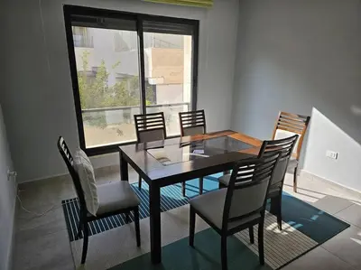 a dining room with a table and chairs and a window at Elite Abdoun area, Amman, 2 Br, 5 guests in Umm Uthainah