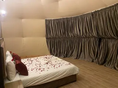 a bedroom with a bed with flowers on it at Titanic Wadi Rum in Disah