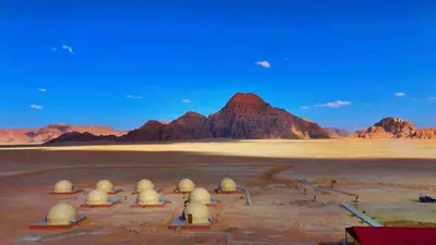 a desert with a group of domes in the desert at Titanic Wadi Rum in Disah