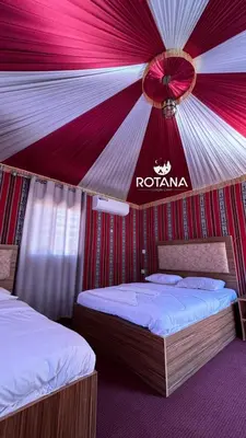 two beds in a room with a red and white tent at Rotana luxury camp in Wadi Rum