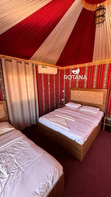 two beds in a room with a red tent at Rotana luxury camp in Wadi Rum