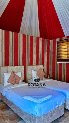 a bed in a room with a red and white tent at Rotana luxury camp in Wadi Rum
