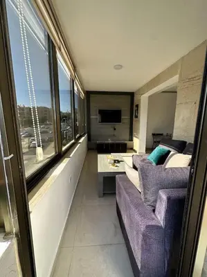 a living room with a purple couch and a tv at abdoun rooftop 1bedroom kh&sh 03 in Amman