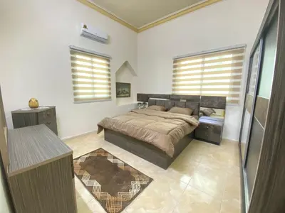 a bedroom with a bed and two windows at The heart of Jabal alweibdeh 2,000 SF entire apartment in Amman