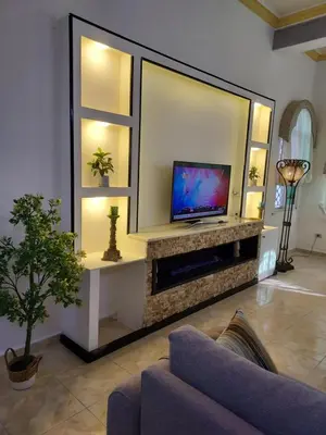 a living room with a tv and a couch at The heart of Jabal alweibdeh 2,000 SF entire apartment in Amman