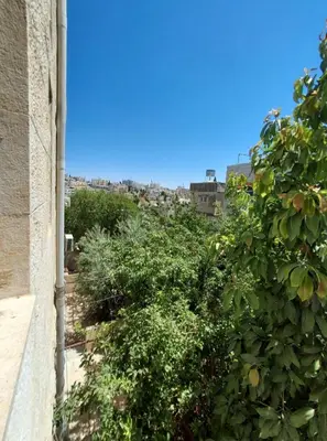 a garden with bushes and trees and a building at The heart of Jabal alweibdeh 2,000 SF entire apartment in Amman