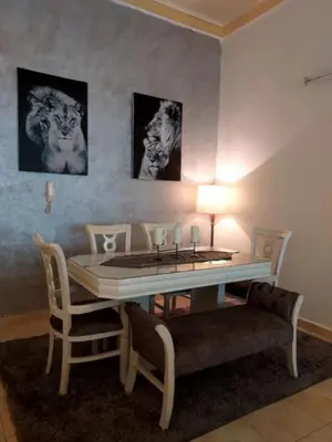 a dining room with a table and chairs and pictures on the wall at The heart of Jabal alweibdeh 2,000 SF entire apartment in Amman