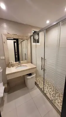 a bathroom with a sink and a glass shower at Residents Specialists in Amman