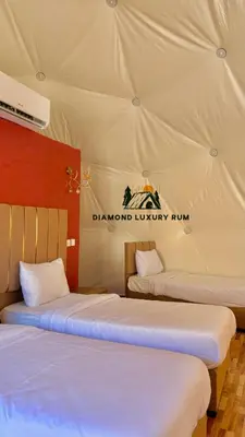 two beds in a tent with the darandon luxury run at Diamond luxury rum in Wadi Rum