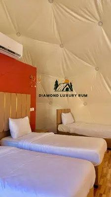 two beds in a tent with the diamond luxury fund sign on it at Diamond luxury rum in Wadi Rum