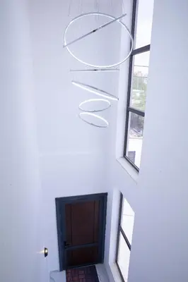 a staircase in a house with a door and a chandelier at The Gray Villas in Sowayma
