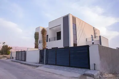 a white house with a gate and a fence at The Gray Villas in Sowayma