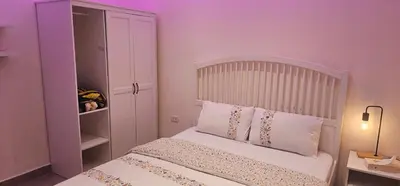 a bedroom with a bed with a pink wall at 2 bedrooms apartment no 13 in Amman