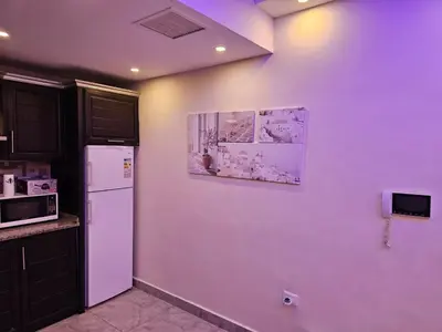 a kitchen with a white refrigerator and a picture on the wall at 2 bedrooms apartment no 13 in Amman