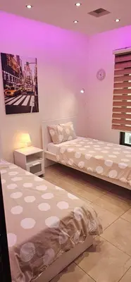 two beds in a room with purple lighting at 2 bedrooms apartment no 13 in Amman