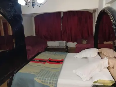a bed in a room with red curtains at 3030 Inn in Irbid