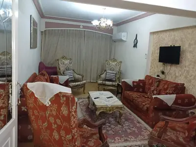 a living room with couches and chairs and a tv at 3030 Inn in Irbid