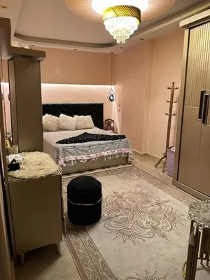a bedroom with a large bed and a chandelier at 3030 Inn in Irbid