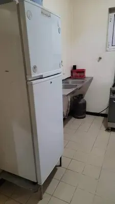 a white refrigerator in a kitchen with a counter at Go there Inn in Az Zarqa