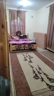 a bedroom with a bed with purple sheets on it at Go there Inn in Az Zarqa