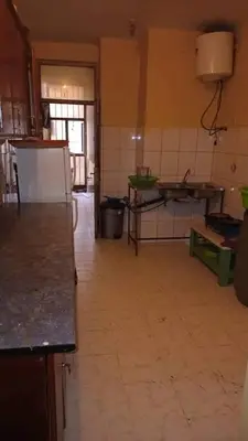a large kitchen with a tiled floor in a room at Go there Inn in Az Zarqa