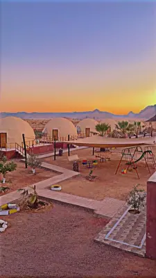 a view of a desert with domes in the distance at Msek wadi rum camp in Disah