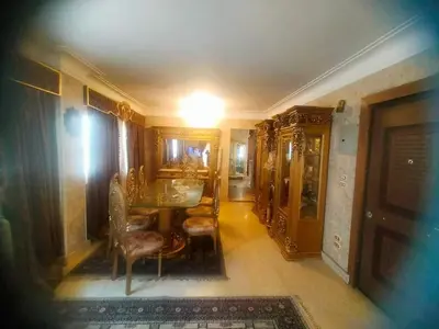 a room with a table and chairs and a hallway at Lotees House in Udhruḩ