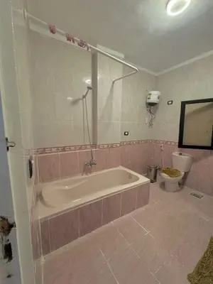 a bathroom with a bath tub and a toilet at Lotees House in Udhruḩ