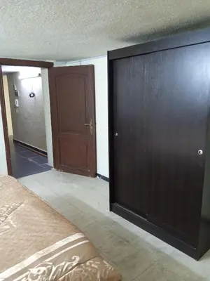 a bedroom with a bed and a large wooden closet at شقة الراحة و الهدوء economic comfortable flat in Amman