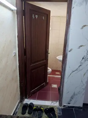 a door to a bathroom with a toilet and some shoes at شقة الراحة و الهدوء economic comfortable flat in Amman