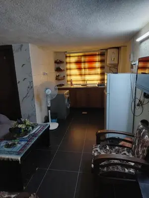 a kitchen with a refrigerator and a table in a room at شقة الراحة و الهدوء economic comfortable flat in Amman