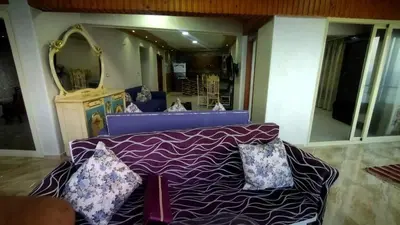 a purple couch with pillows in a room with a mirror at Rest Inn in Kerak