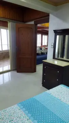 a bedroom with a bed and a dresser and a mirror at Rest Inn in Kerak