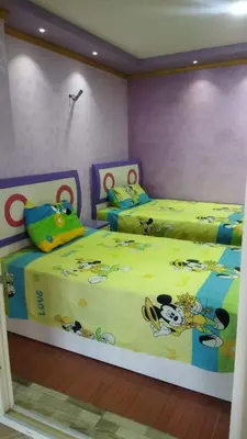 a bedroom with two beds with winnie the pooh and micrats at Rest Inn in Kerak