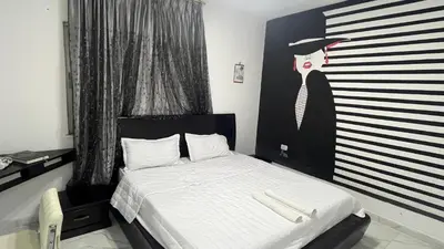 a bedroom with a bed with a painting of a woman at Bait Al-Masri in Um Qeis