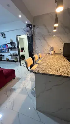 a kitchen with a counter and chairs in a room at Bait Al-Masri in Um Qeis