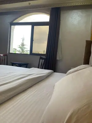 two beds in a room with a window at زهرة المدائن in Jerash