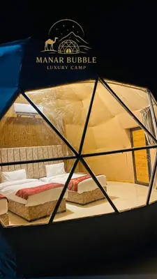 a tent with two beds inside of it at Manar Bubbel Luxury Camp in Wadi Rum