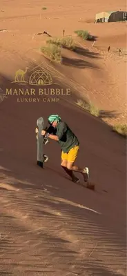 a man in yellow shorts playing with a fire hydrant at Manar Bubbel Luxury Camp in Wadi Rum