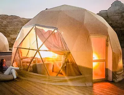 a woman is sitting in a dome tent at MOON RUM lUXURY CAMP in Wadi Rum