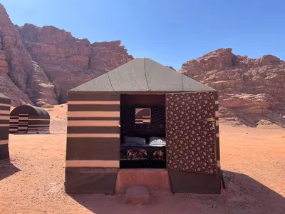 a small house in the desert with an american flag at Um sabatah camp in Wadi Rum